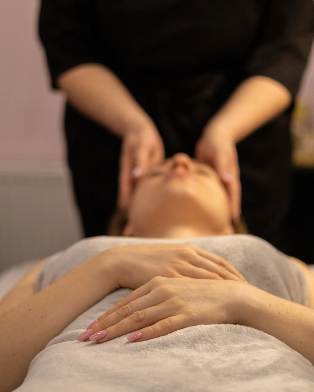 Mujer recostada recibiendo un masaje facial