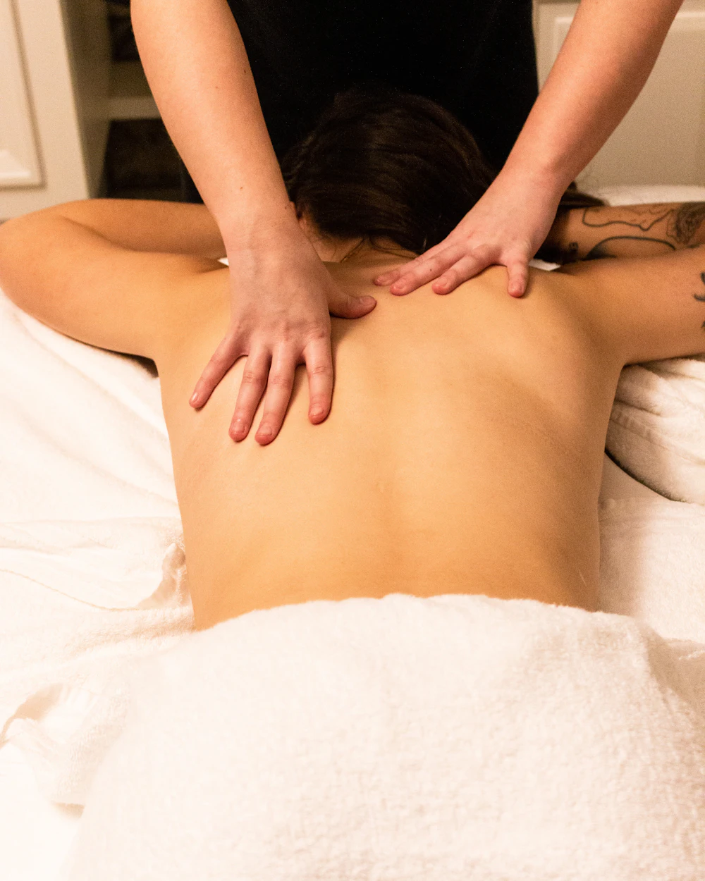 Terapeuta dando un masaje de espalda en una cabina